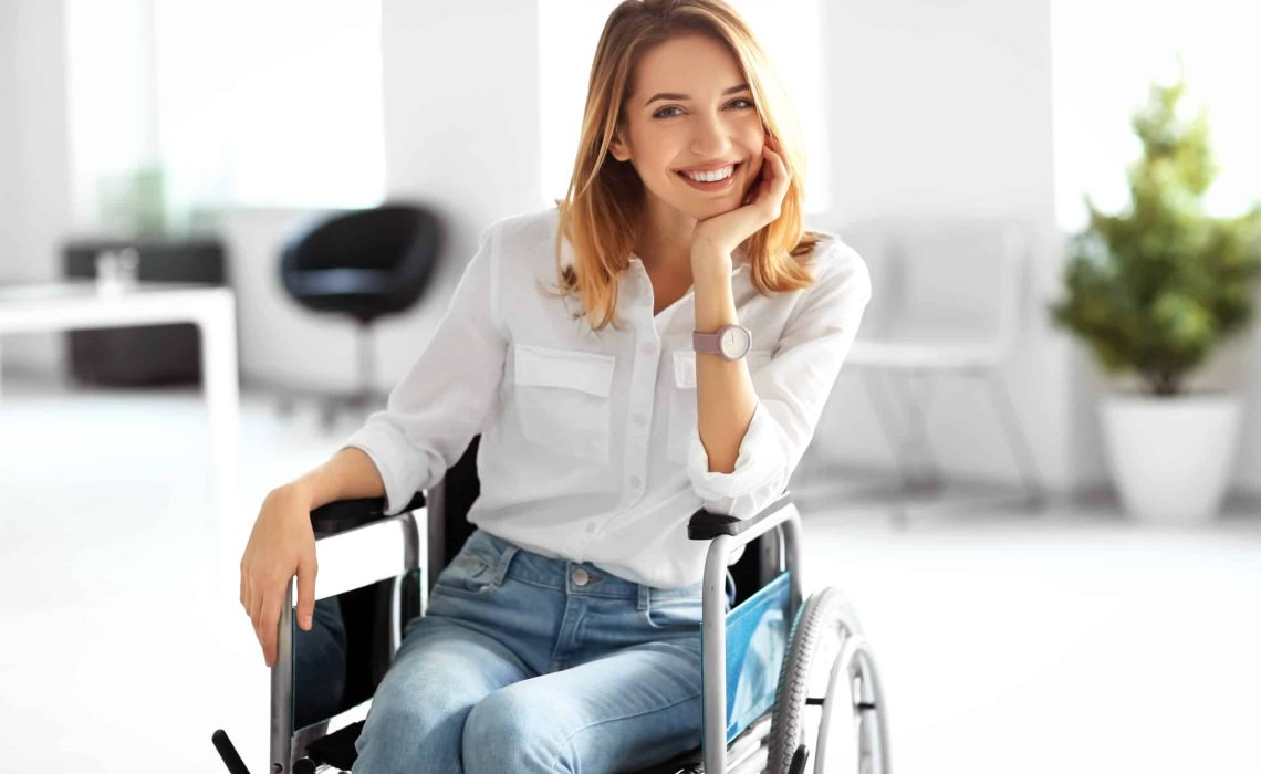 Young woman in wheelchair at workplace