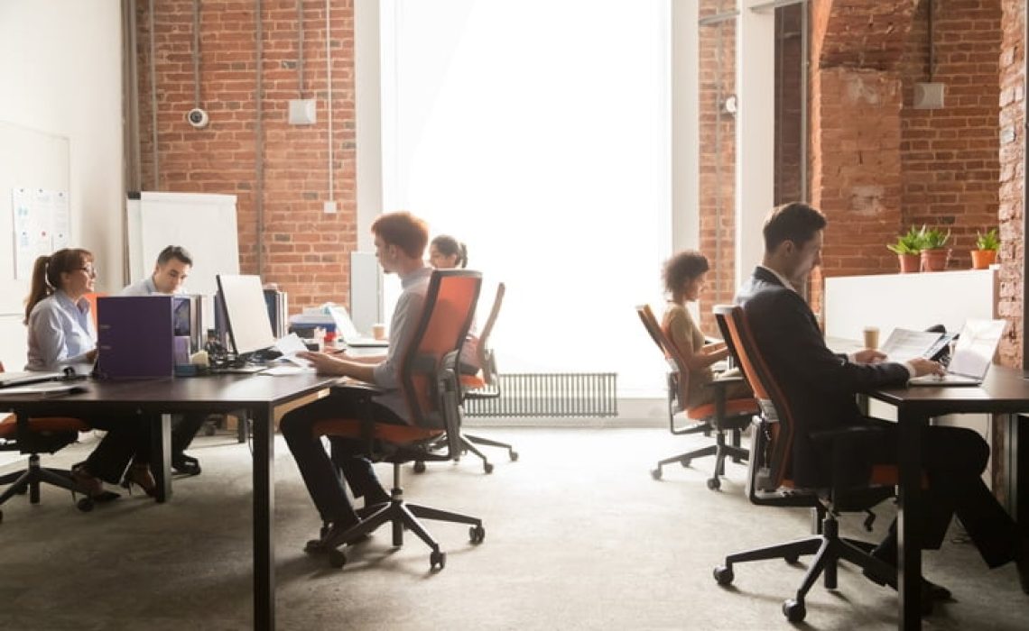 Business team workers working on computers in modern coworking enterprise Business team women men workers working on computers in modern big coworking enterprise space, busy staff diverse professional employees office people group sitting at desks using pc at workplace