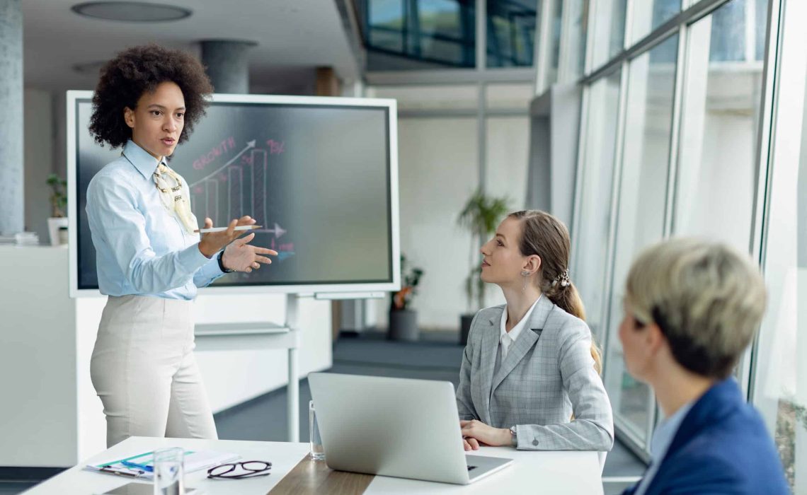 Black female entrepreneur talking while holding business presentation in the office.