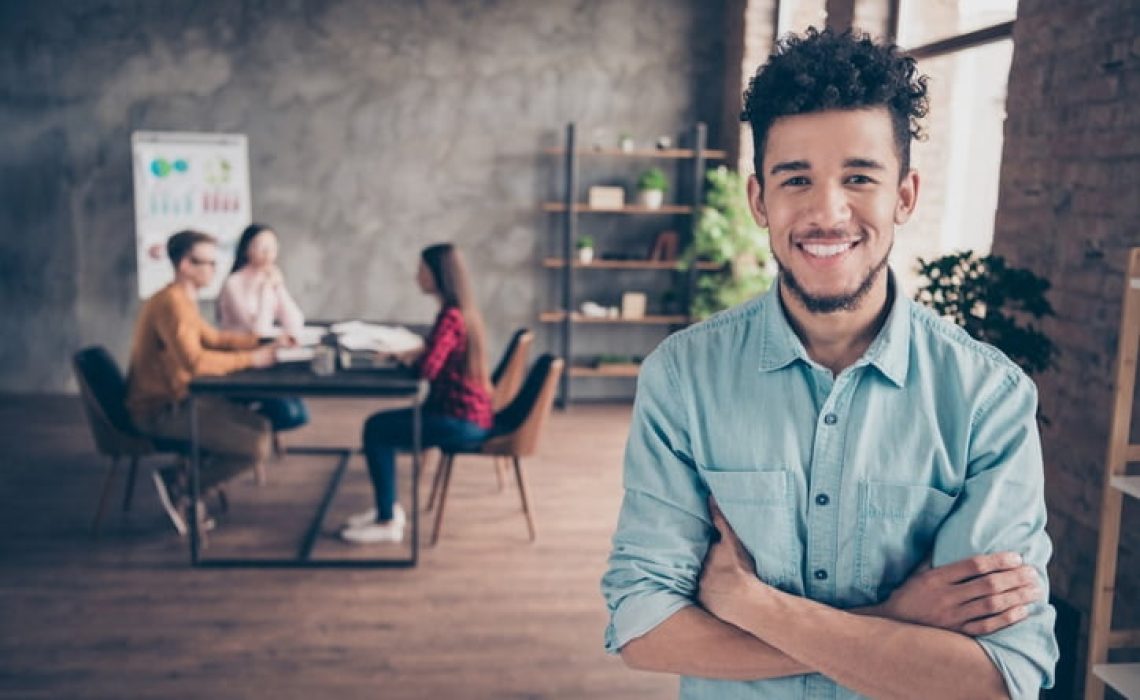 Portrait of nice attractive content cheerful guy shark hr director executive manager, wearing blue shirt folded arms career development table at industrial loft interior workplace workstation