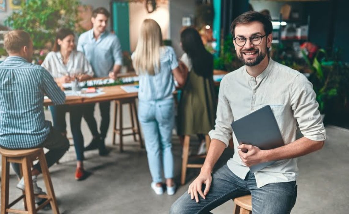 Group of young business people are working together in modern office. Creative people with laptop, tablet, smart phone, notebook. Successful hipster team in coworking. Freelancers.