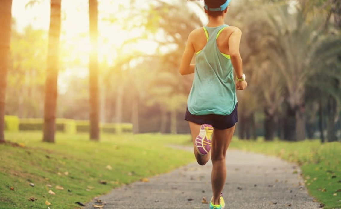 healthy lifestyle young sporty asian woman running at tropical park